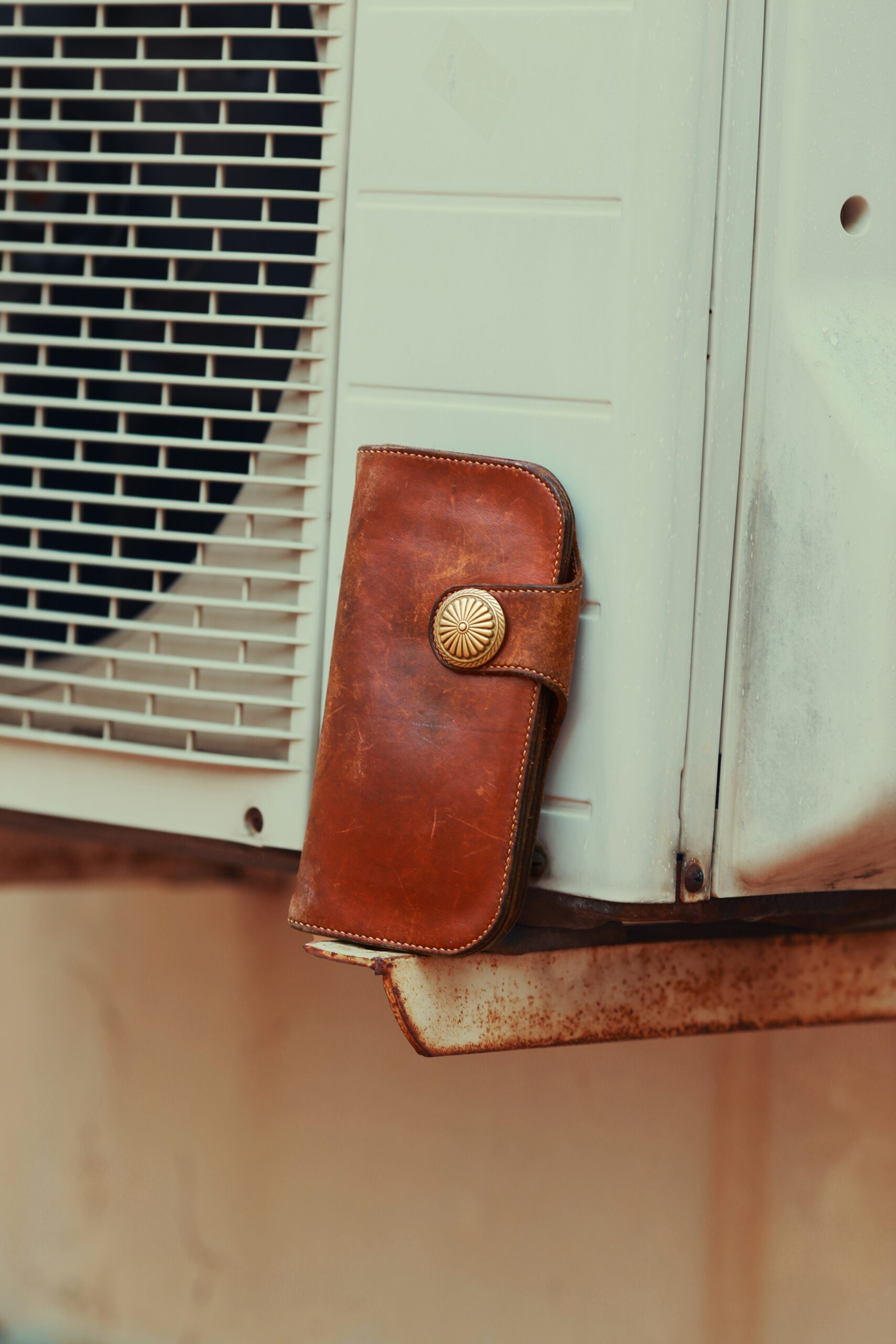 a brown wallet sitting on top of a window sill